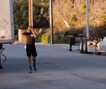 a man wearing a mask is walking down a street in front of a white truck