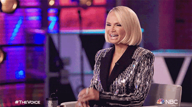 a woman in a sequined jacket is sitting in a chair on nbc