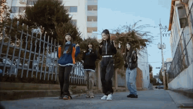 a group of girls are walking down a street with one wearing a sweatshirt that says edgy on it