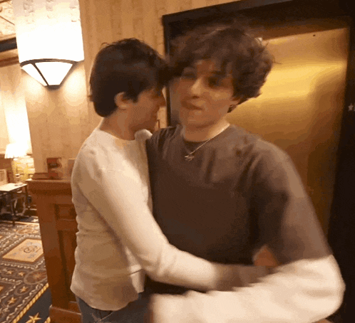 a man and a woman are hugging in front of a door