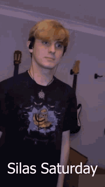 a young man wearing headphones and a black shirt with silas saturday written on it