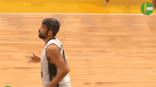 a man in a basketball uniform is pointing at something in the air