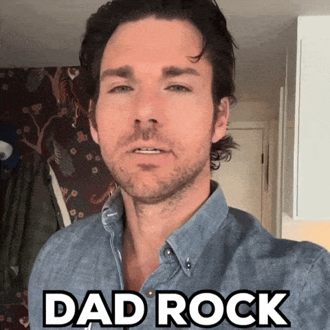 a man in a denim shirt says " dad rock " on his face