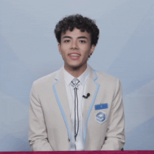 a young man wearing a suit and tie with a patch that says g9