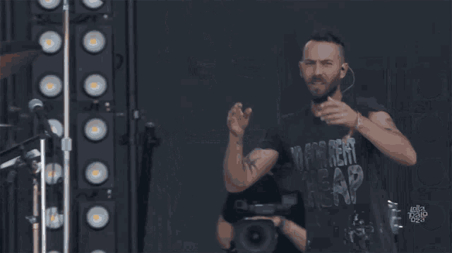 a man with his arms in the air wearing a black shirt that says monkey crew