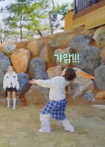 a girl is throwing a frisbee in the air while another girl looks on .