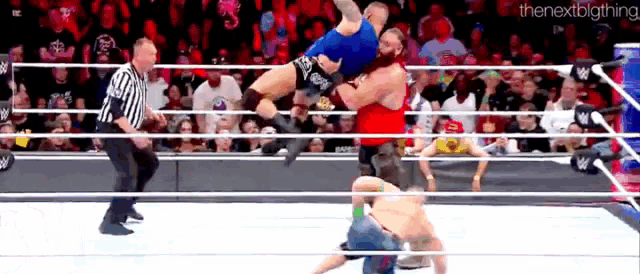a wrestler is being lifted in the air by another wrestler during a match in a wrestling ring .