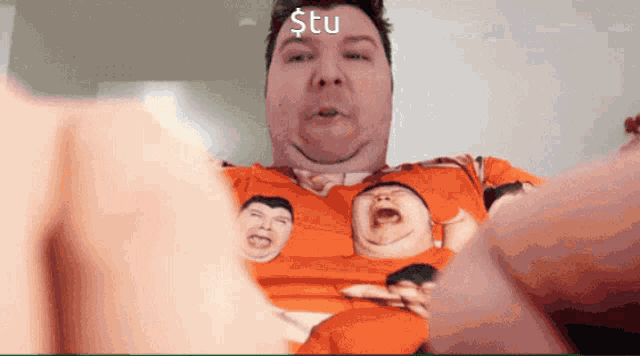 a man wearing an orange shirt with a picture of a baby on it