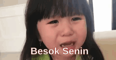 a little girl is crying with the words besok senin written on the bottom .