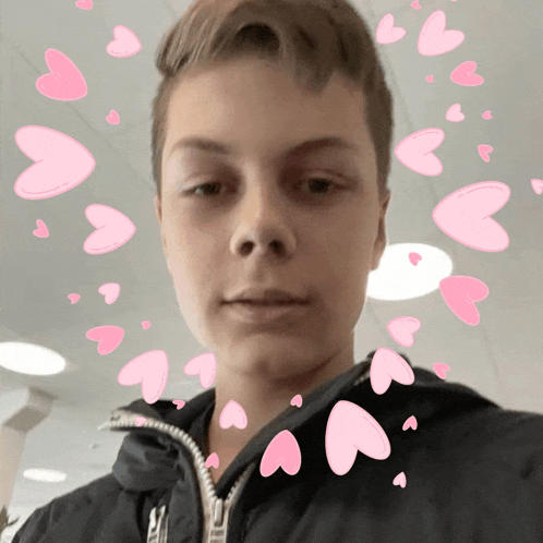 a boy with pink hearts around his face