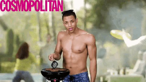 a shirtless man is cooking on a grill in front of a cosmopolitan ad