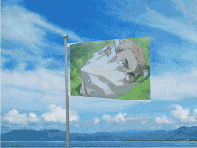 a green and white flag is flying in the wind near the ocean
