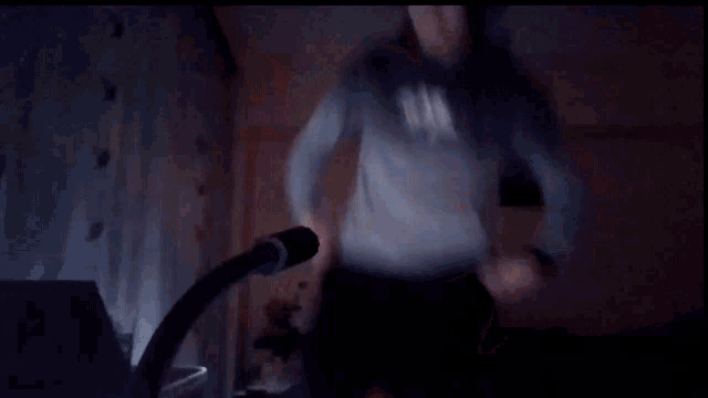 a blurry picture of a person 's torso with a microphone in the foreground