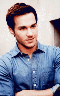 a man wearing a blue shirt has his arms crossed