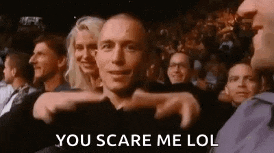 a man is pointing at a woman in a crowd of people and says `` you scare me lol '' .
