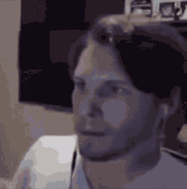 a man with a beard is making a funny face while looking at the camera .