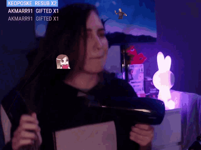 a woman is holding a hair dryer in front of a screen that says akmarr91 gifted x1 on it