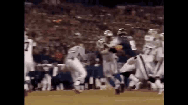 a football game is being played in front of a crowd of people .
