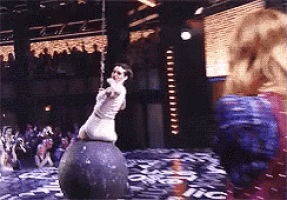 a woman is standing on top of a ball with a rope around her neck