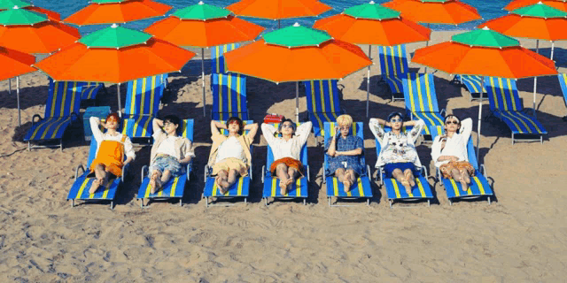 a group of people laying on a beach under umbrellas