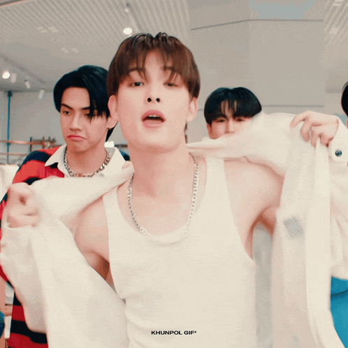 a man in a white tank top is being photographed by khunpol gif *