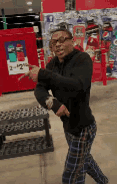 a man in plaid pants is dancing in a store