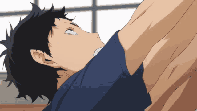 a man with a blue shirt on is laying down with his eyes closed