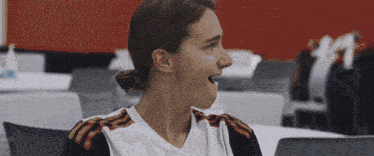 a woman with her mouth open wearing a white shirt with red stripes