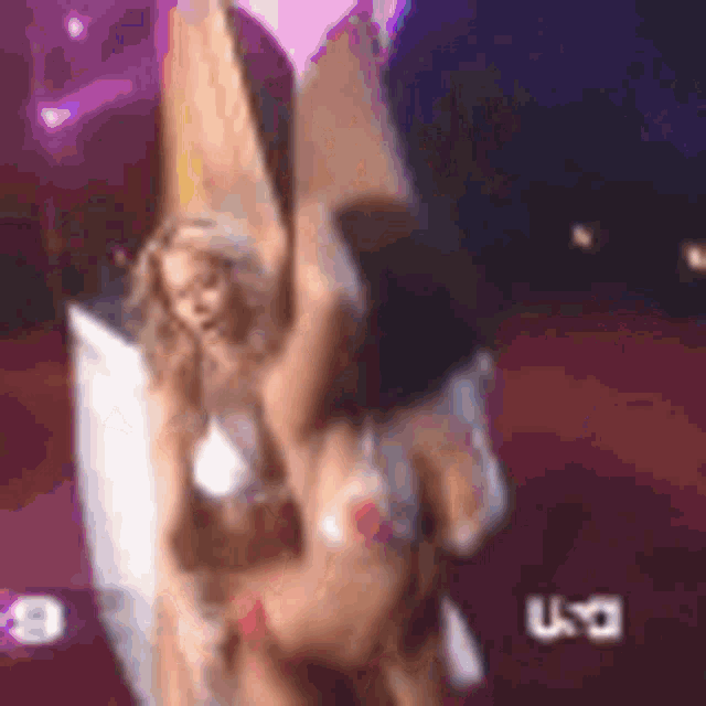 two women in bikinis are dancing on a stage .