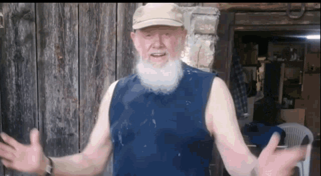 an older man with a beard wearing a blue tank top and a hat