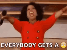 a woman in a red shirt is holding a microphone with her arms outstretched and says everybody gets a