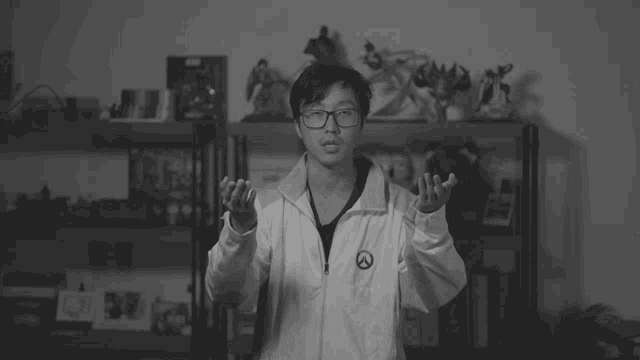 a black and white photo of a man wearing glasses and a white jacket