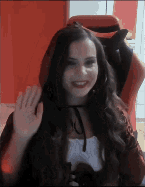 a woman sitting in a red chair with her hand out