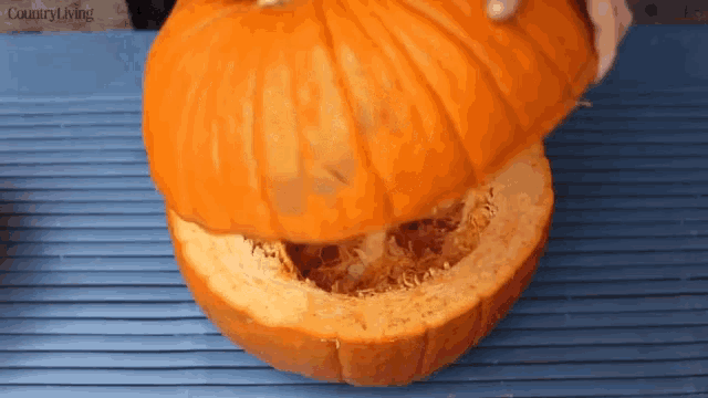 a pumpkin that has been cut in half is sitting on a blue cutting board that says country living