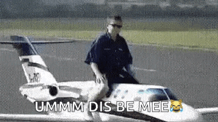 a man is riding on the back of a small airplane on a runway .