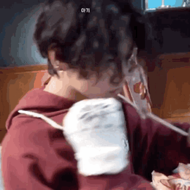 a person with curly hair is drinking from a straw .