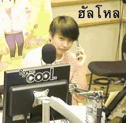 a boy is talking on a cell phone in front of a cool computer