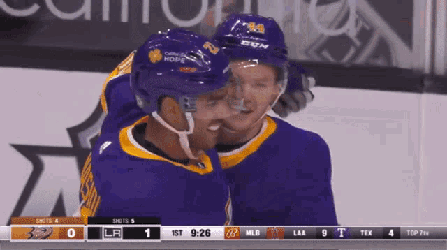 a hockey player wearing a ccm helmet hugs another player