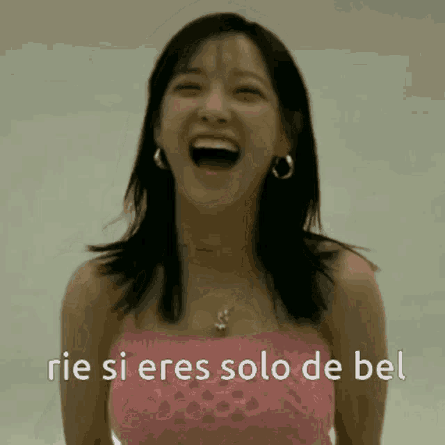 a woman in a pink top is laughing with the words " rie si eres solo de bel " above her