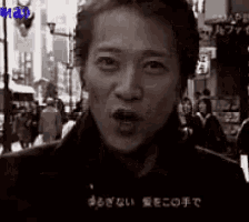 a black and white photo of a man making a funny face .