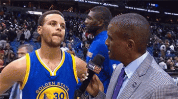 golden state warriors basketball player stephen curry is being interviewed by a man in a suit .