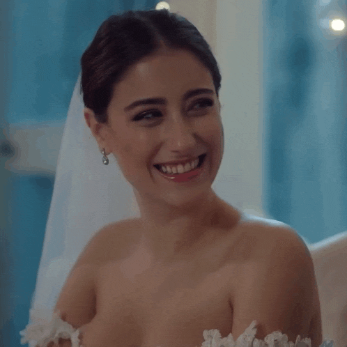 a woman in a white wedding dress is smiling
