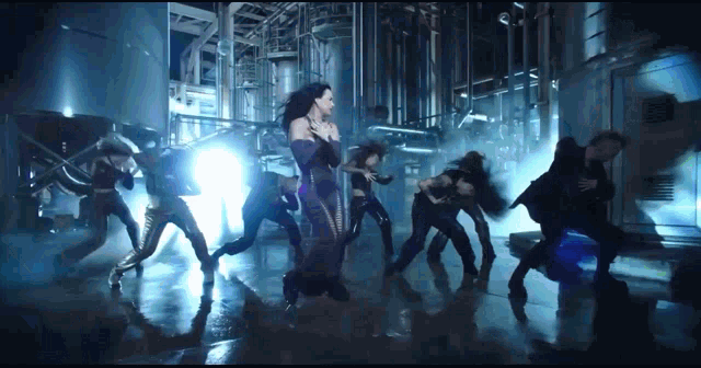 a woman in a purple dress is surrounded by dancers