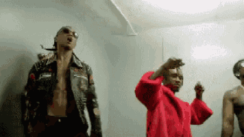 a group of men are standing next to each other in a room dancing .