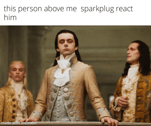 a man in a suit is standing next to two other men and a caption that says this person above me sparkplug react him