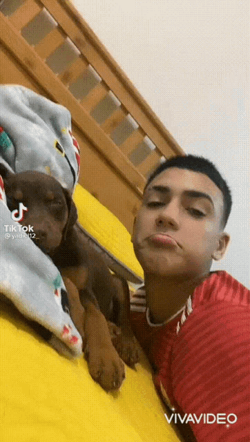 a young man is laying on a bed with a puppy and a tiktok watermark