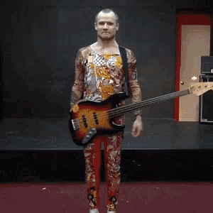 a man is holding his head while playing a guitar