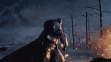 a man in a knight 's armor is holding a torch in front of a wolf .