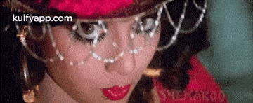 a close up of a woman 's face with red lipstick and a hat .