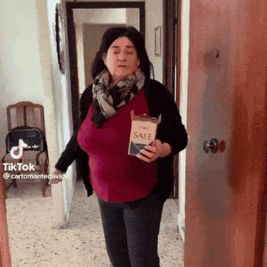 a woman is holding a bag of salt and a tiktok sticker